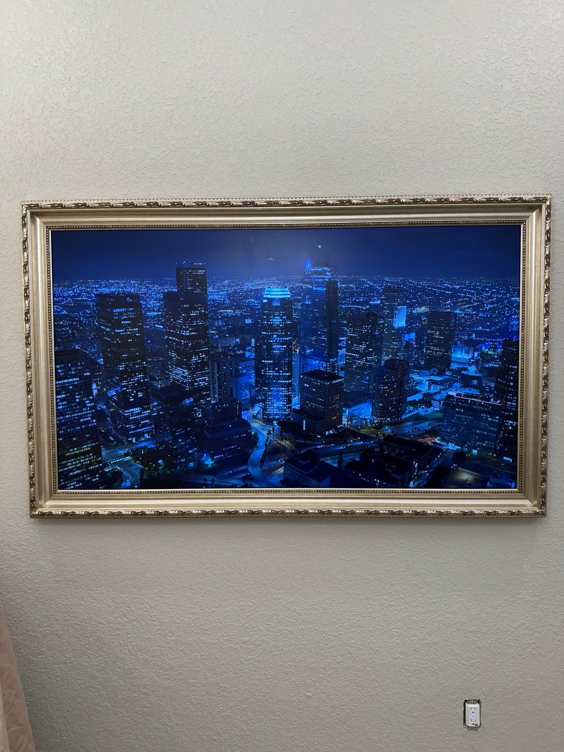 Wall-mounted television with a decorative gold frame