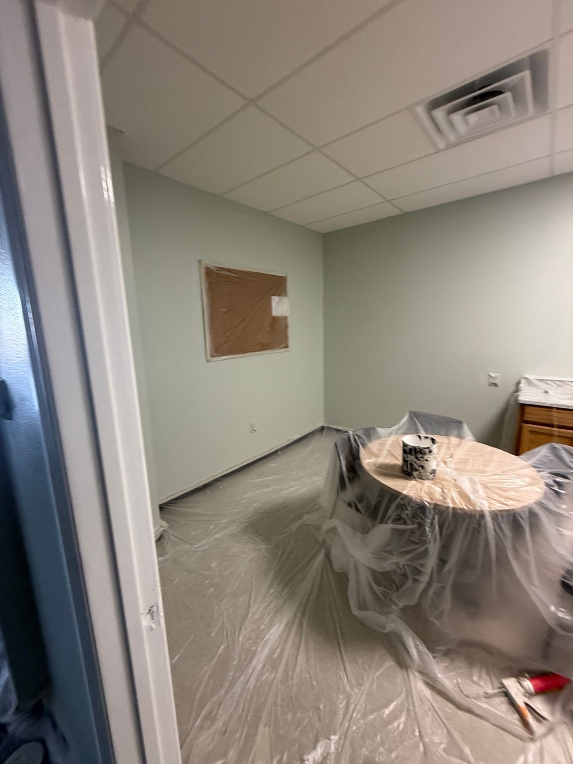 Commercial interior prepared for painting with protected furniture and floors